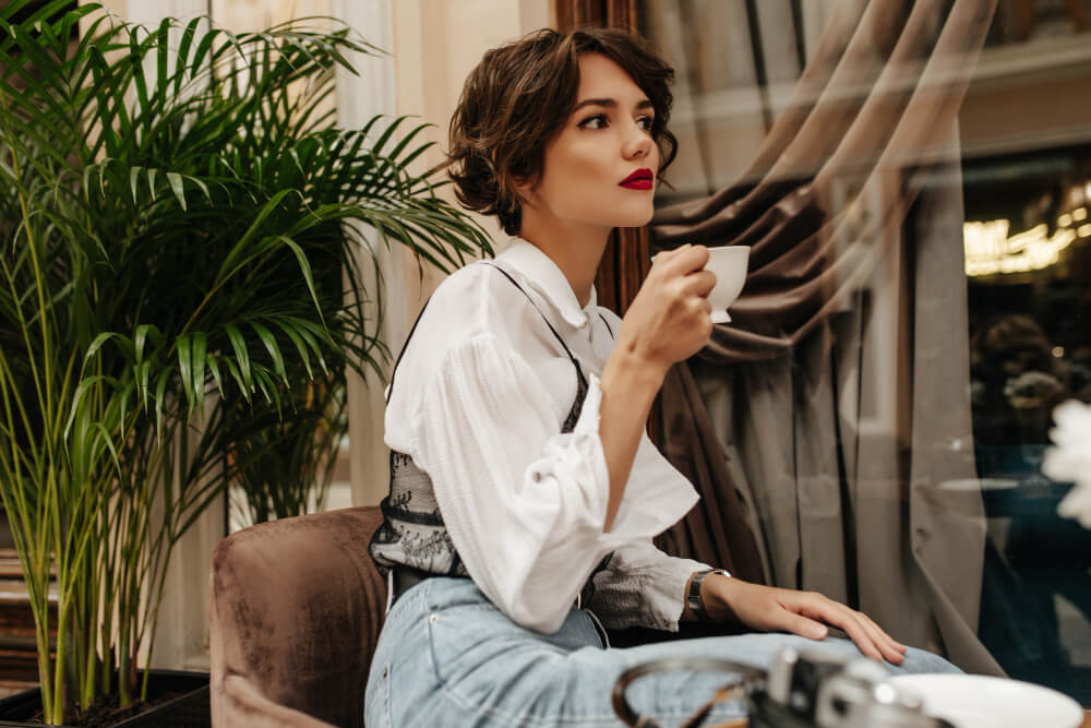 Mulher elegante tomando café em ambiente sofisticado